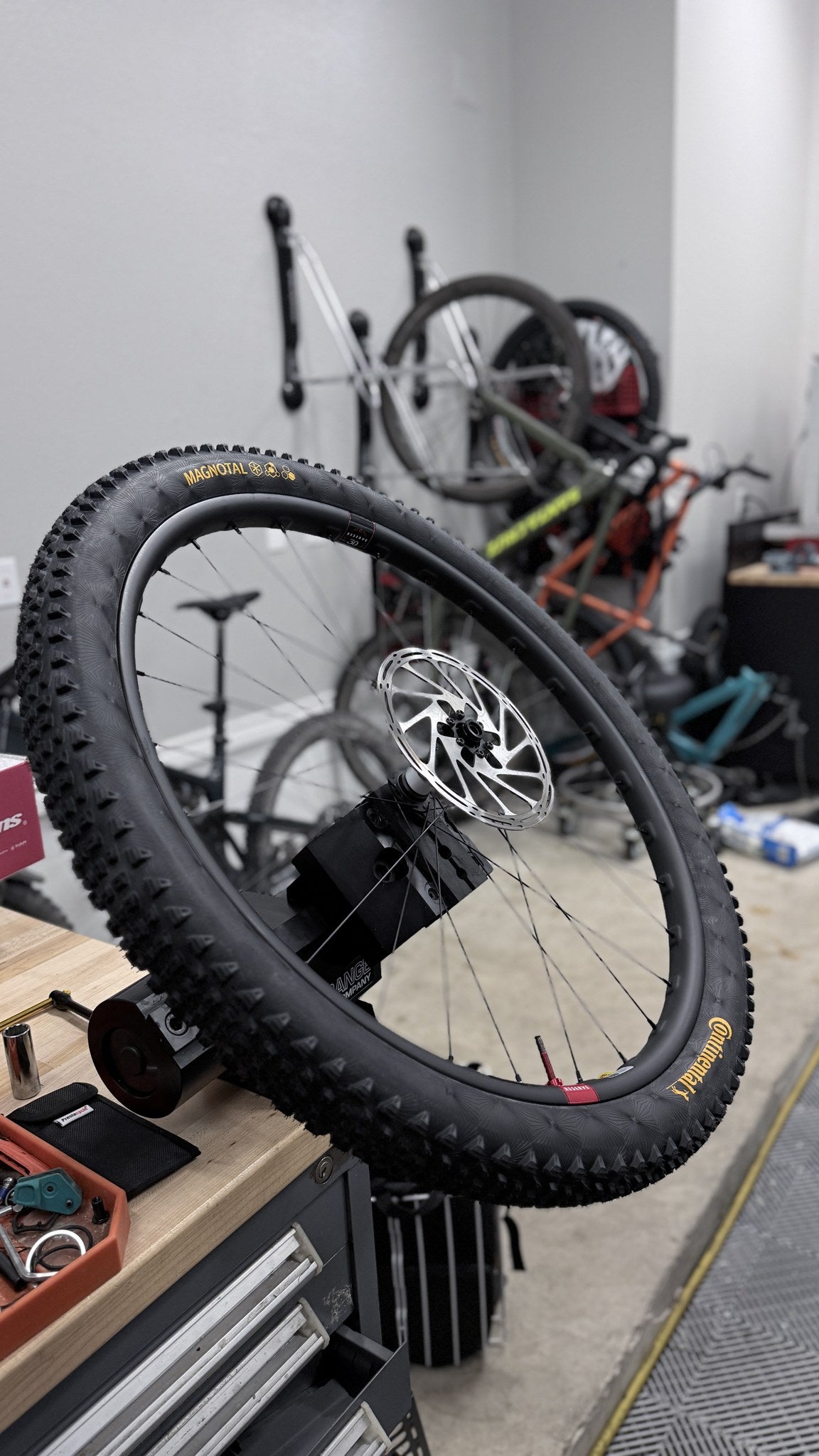 Mountain bike wheel held by its thru-axle in ZED0 soft jaws in an Orange bench vise